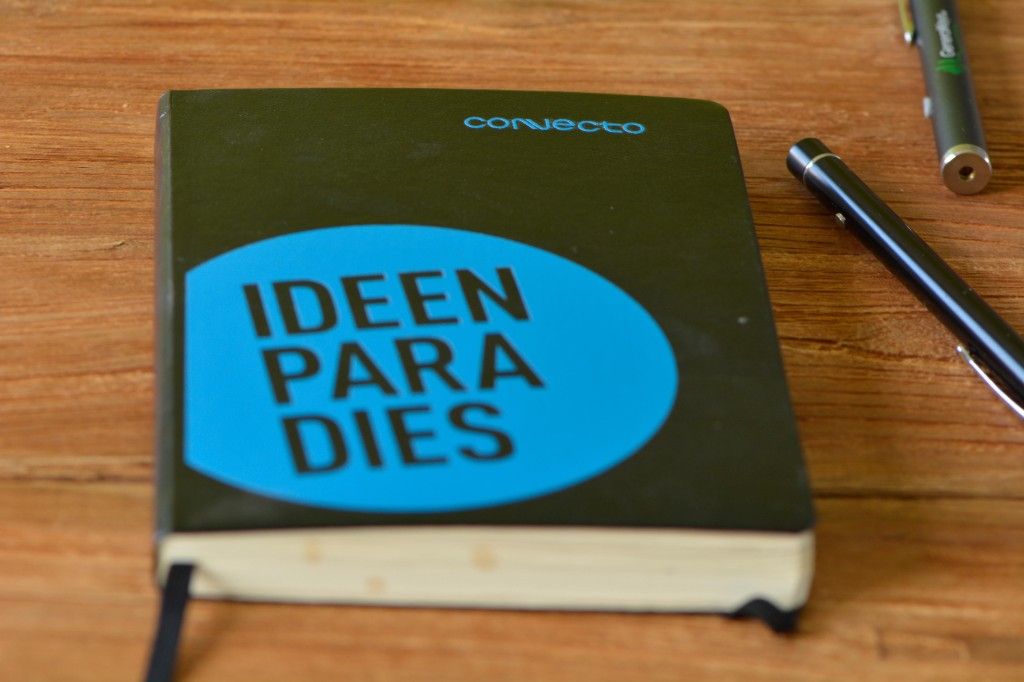 Notebook with the Convecto logo and the word “Ideenparadies” next to two pens