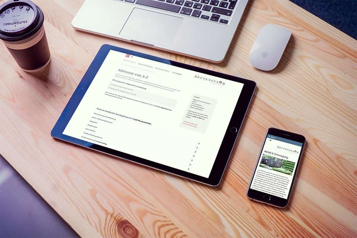 Tablet showing the A to Z directory and smartphone showing the waste disposal page on a wooden table