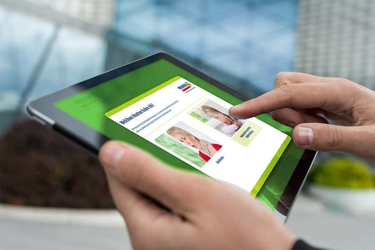 Hand holding a tablet with the Prospan cough test: “Welchen Husten habe ich?” (what kind of cough do I have?)