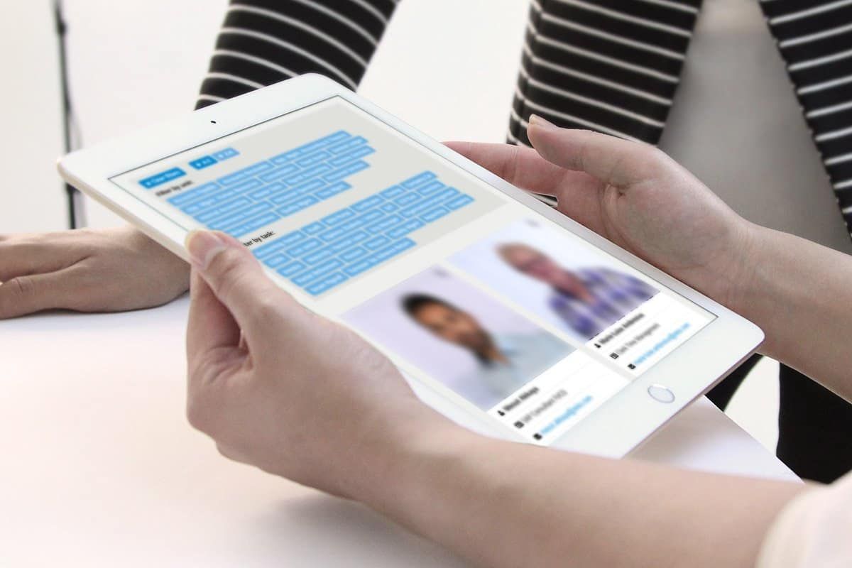 Hands holding a tablet with filters by unit and by task and the contact cards of two people